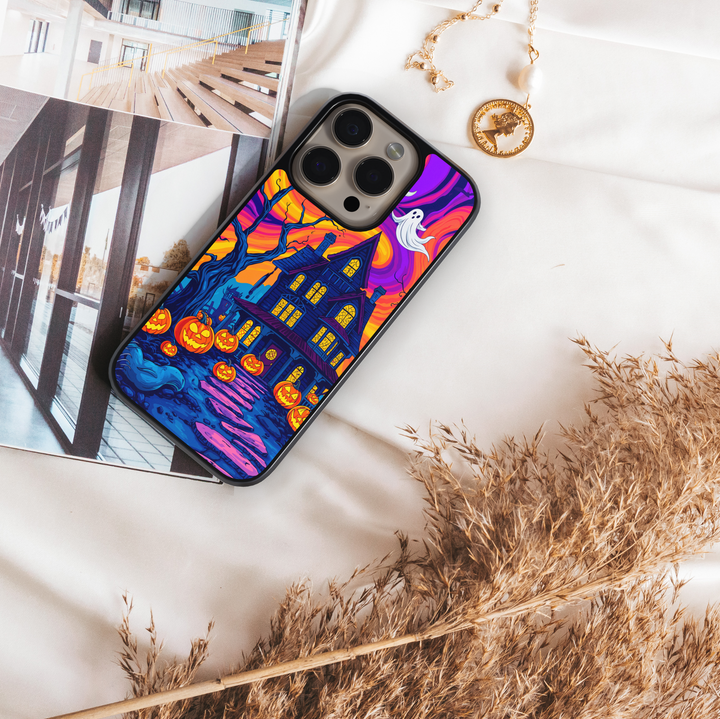 Halloween haunted house phone case with glowing pumpkins, ghosts, bats, and colorful night sky – spooky protective iPhone and Samsung Galaxy cover for Halloween aesthetic
