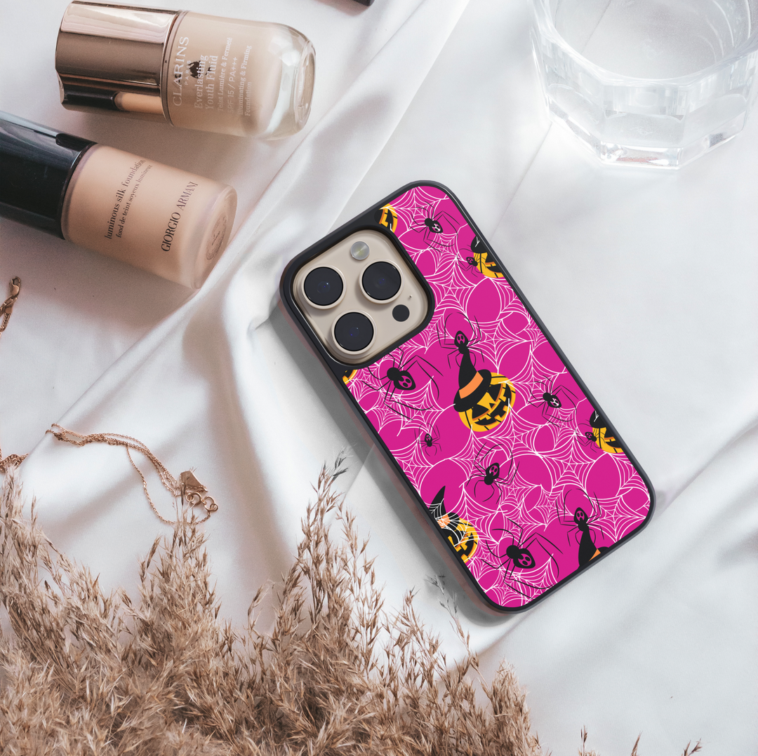 Girly pink Halloween iPhone case with spider webs, pumpkins, and cute spooky design.