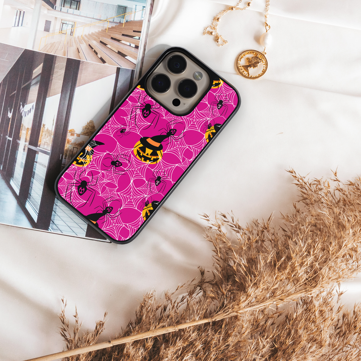 Girly pink Halloween iPhone case with spider webs, pumpkins, and cute spooky design.