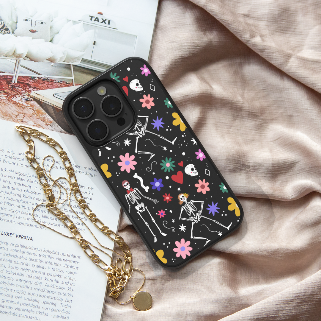 Black iPhone case with colorful skeletons, flowers, and hearts – cute Halloween girly aesthetic phone cover