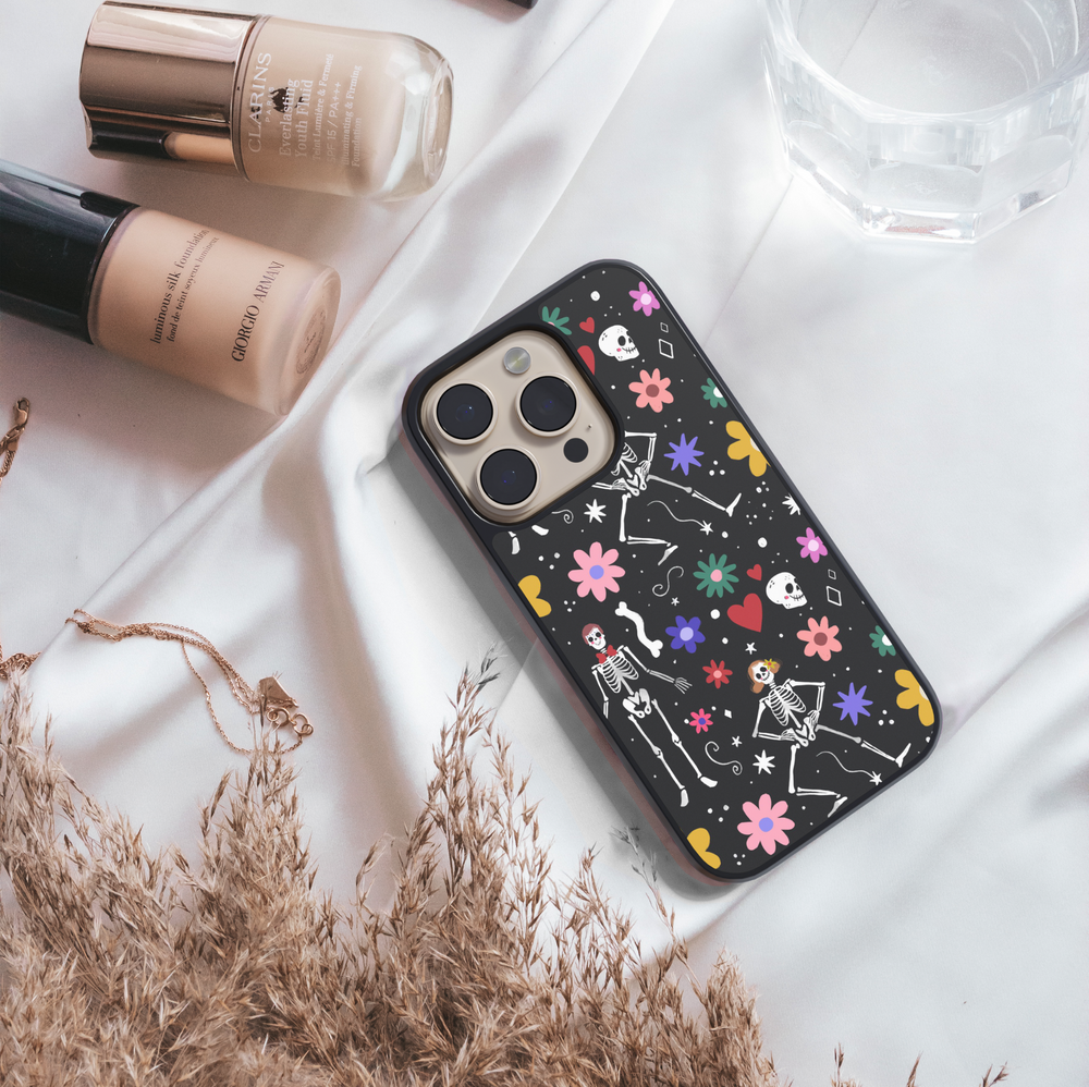 Black iPhone case with colorful skeletons, flowers, and hearts – cute Halloween girly aesthetic phone cover