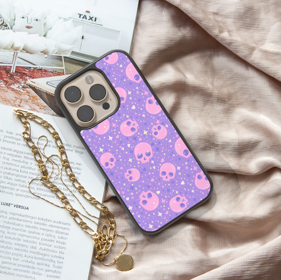 Pastel skull iPhone case with purple background, sparkly stars, pink kawaii skull pattern, gothic cute phone cover, aesthetic Halloween iPhone accessory