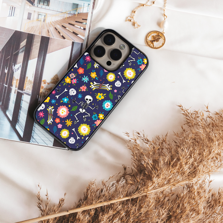 Skeleton floral Halloween phone case with colorful flowers, skulls, and bones on dark navy background – protective iPhone and Samsung cover