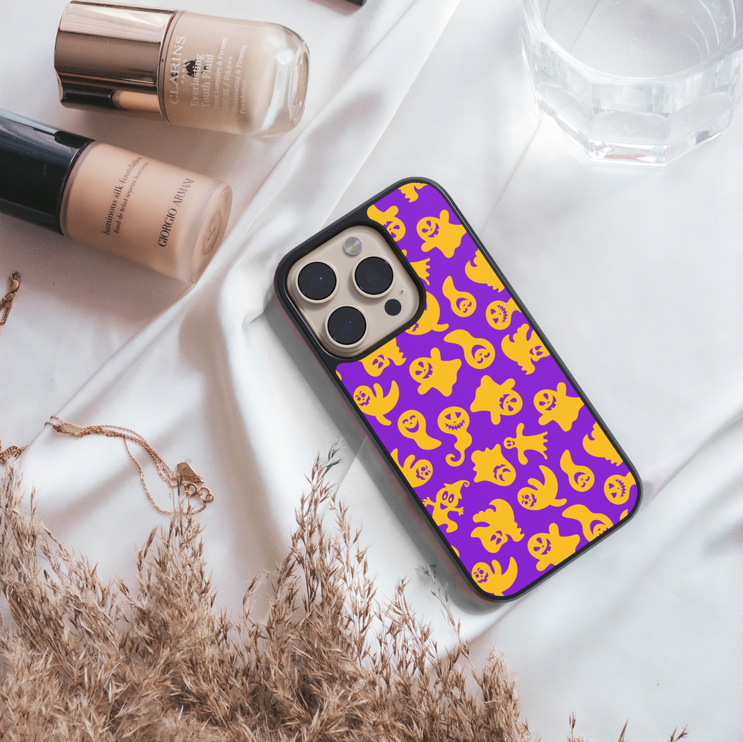 Halloween pumpkin and witch hat iPhone case with ghost, bat, and star pattern on cream background.