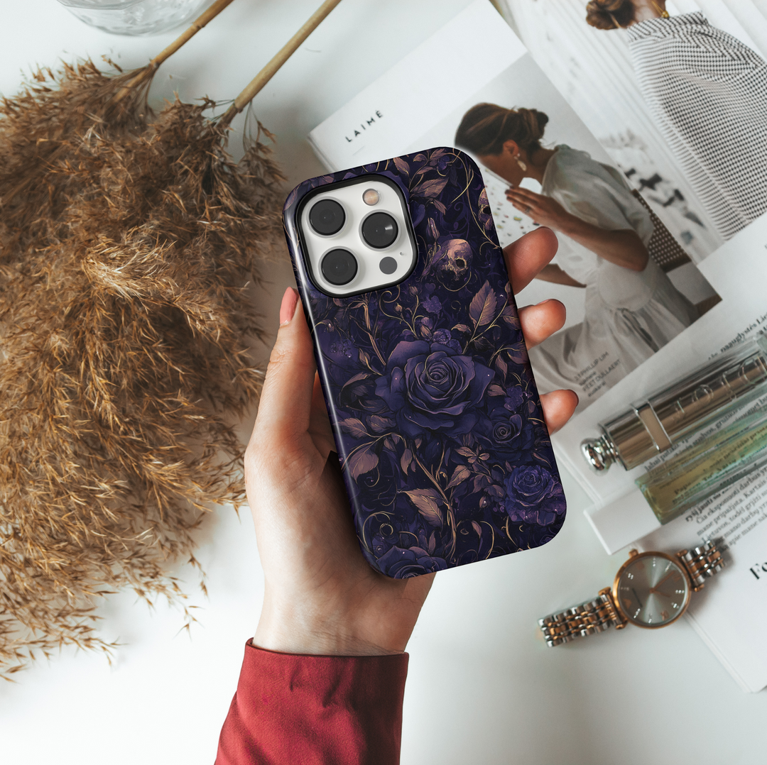 Gothic Halloween phone case with dark purple roses, vintage skull accents, moody floral pattern, spooky fall aesthetic cover for iPhone.