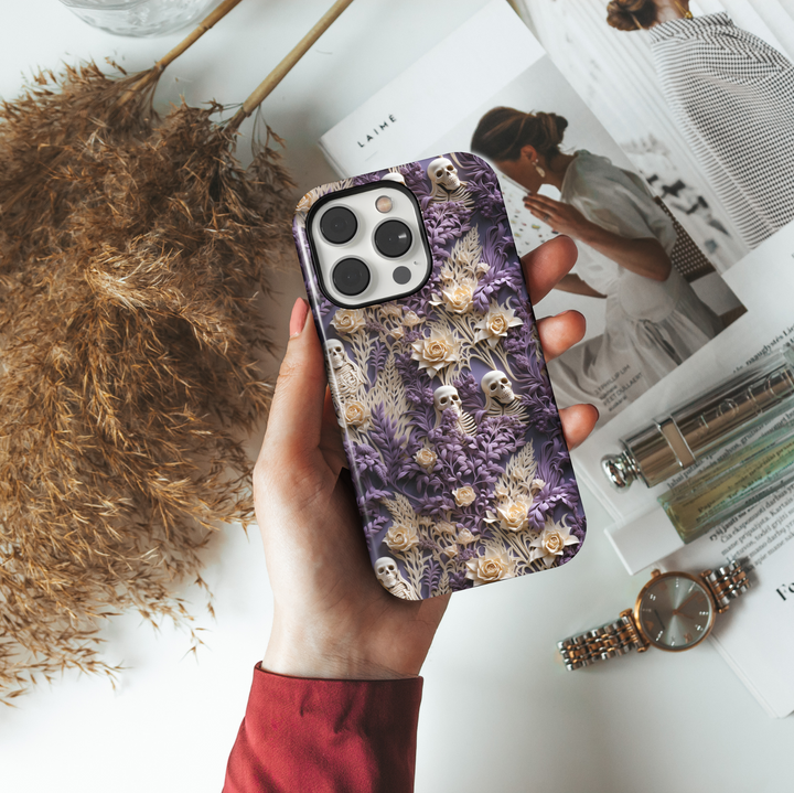 Skeleton and floral iPhone case with beige skulls and cream roses hidden in purple botanical foliage, perfect for gothic Halloween or spooky aesthetic lovers.