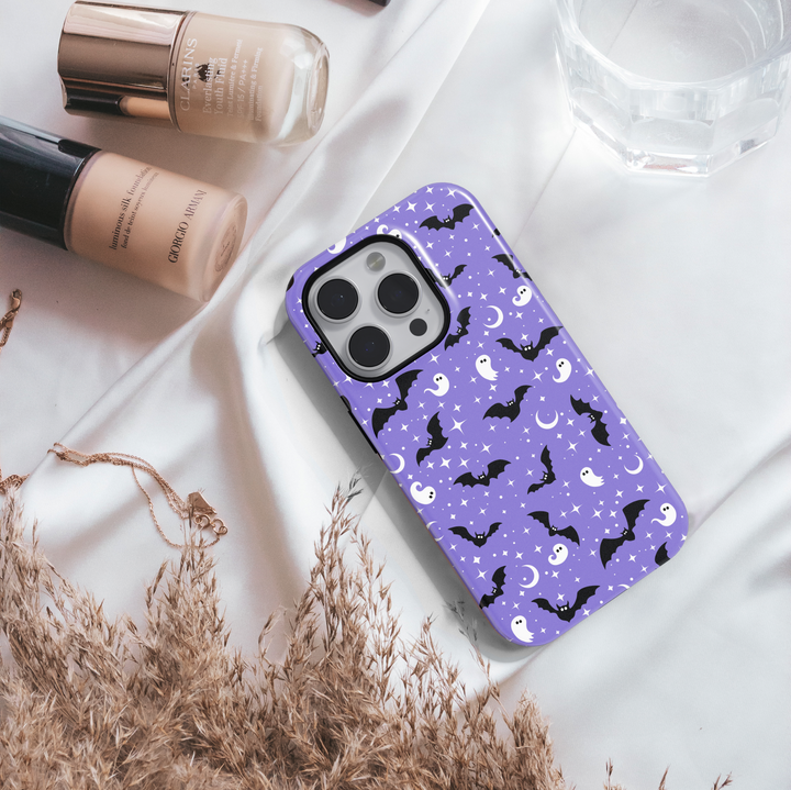 Purple tough phone case with cute white ghosts, black bats, moons, and stars – Halloween aesthetic protective iPhone and Samsung cover.