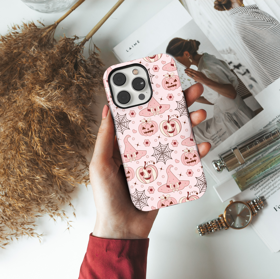 Pink Halloween iPhone case with pastel pumpkins, witch hats, hearts, and spiderwebs for iPhone 16 Pro Max, 15, 14, and 13