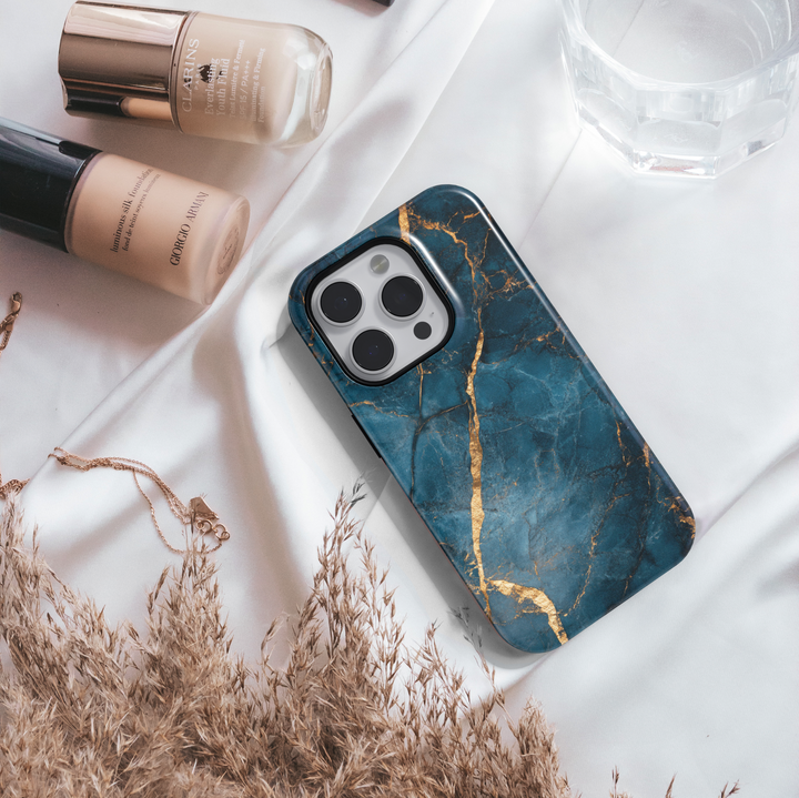 Elegant iPhone case with deep blue marble texture and gold vein detailing; MagSafe-compatible tough case for iPhone 16.