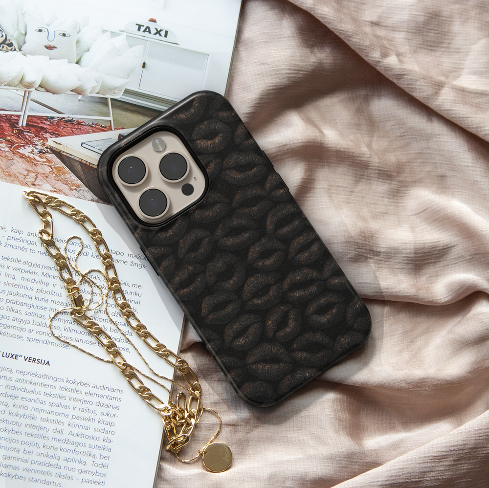 Glossy black iPhone case featuring a textured dark lip print pattern, stylish and edgy design for iPhone 16 series, MagSafe compatible.