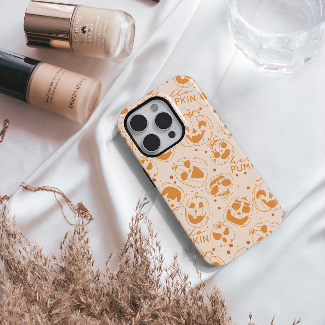 Pumpkin doodle Halloween phone case with orange jack-o’-lantern designs on a neutral background for iPhone and Samsung.