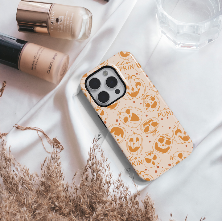 Pumpkin doodle Halloween phone case with orange jack-o’-lantern designs on a neutral background for iPhone and Samsung.