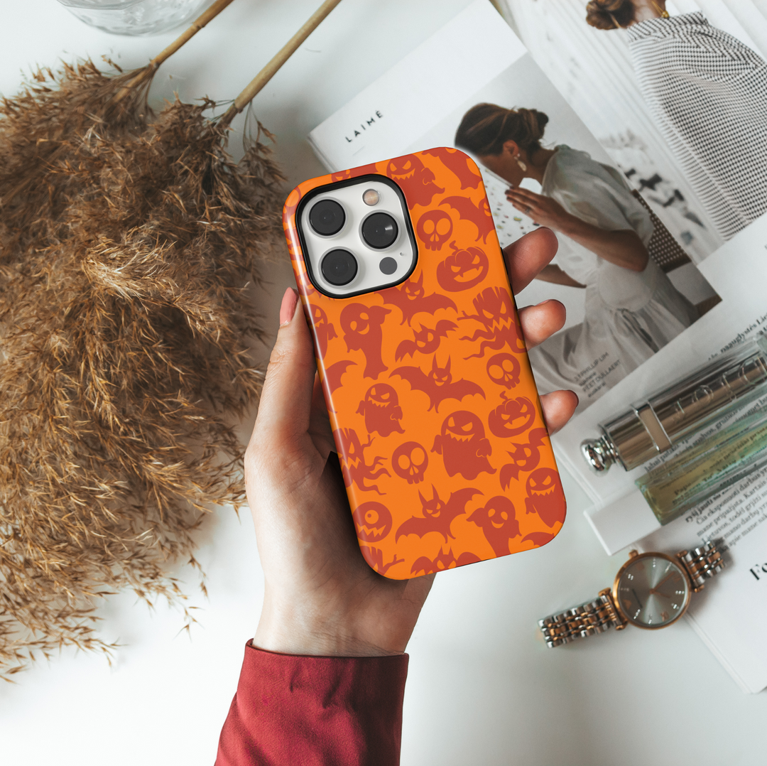 Orange Halloween iPhone case featuring a seamless pattern of spooky red ghosts, bats, pumpkins, skulls, and creepy eyes for a fun and festive look.