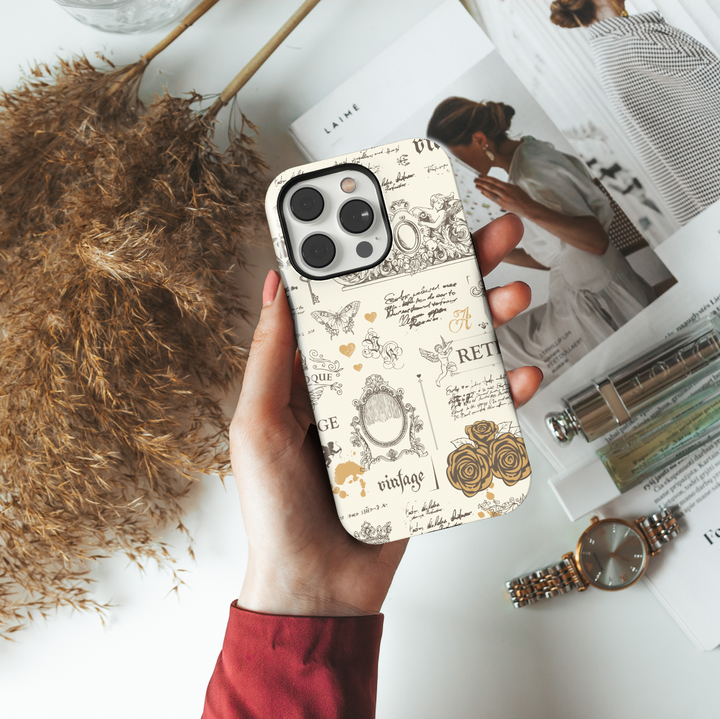 Cream vintage aesthetic iPhone case with antique sketches of cherubs, roses, ornate frames, French script, butterflies, and baroque elements.