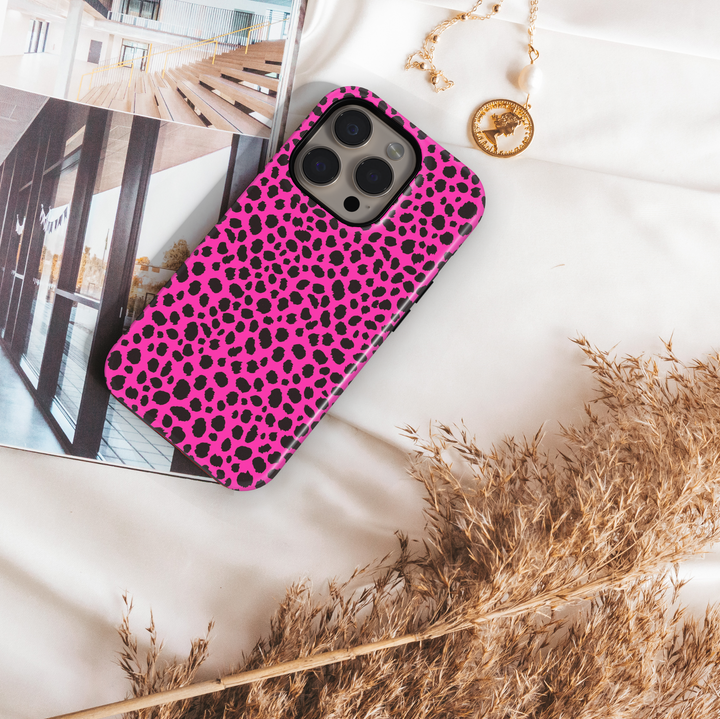 Hot pink leopard print iPhone case with bold black animal spots, designed for iPhone 16 series and MagSafe compatible, featuring a girly wild aesthetic.

