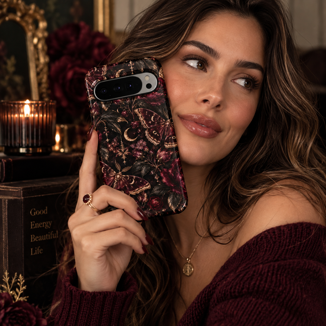Midnight Moth Garden Google Pixel case featuring burgundy moths, crescent moons, deep wine flowers, dark botanical leaves and antique gold celestial details on a black background.