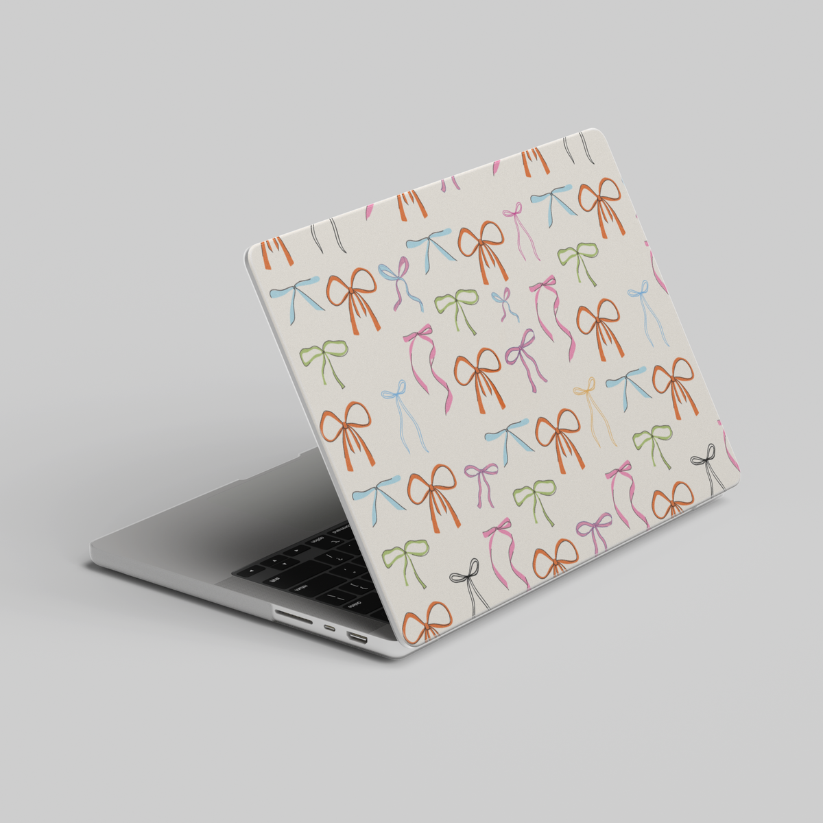 Playful MacBook case with colorful hand-drawn ribbon bows on a cream background, perfect for students, creatives, and aesthetic laptop setups.