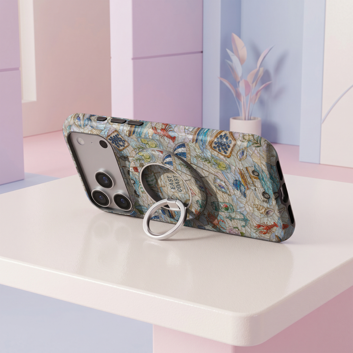 Coastal Escape MagSafe ring holder with pearl-inspired seaside design featuring sailboats, lighthouse, beach umbrella and ocean details with silver rotating magnetic phone grip.