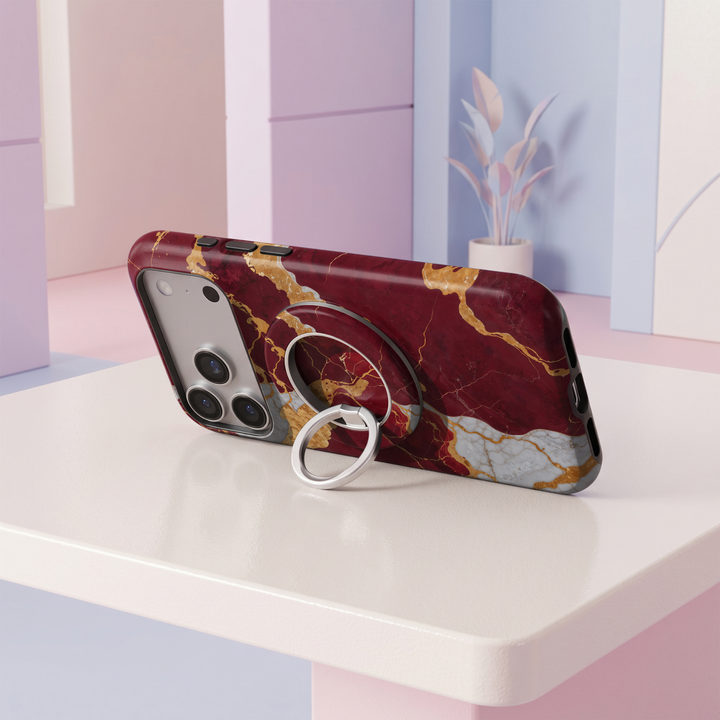 Burgundy Gold Marble MagSafe ring holder featuring a rich wine red marble design with bold metallic gold and white veining, finished with a sleek silver magnetic phone grip and stand.