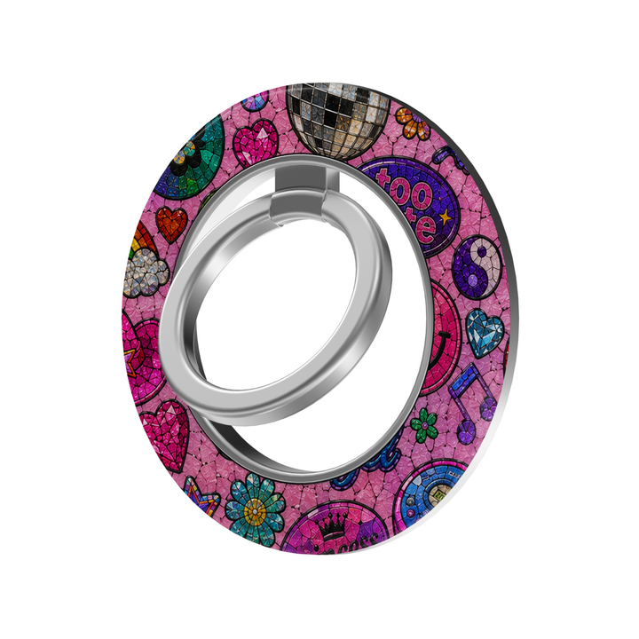 Colorful pink stained glass MagSafe ring holder featuring disco balls, hearts, rainbows, flowers, stars, and retro pop icons with a silver phone grip and stand.