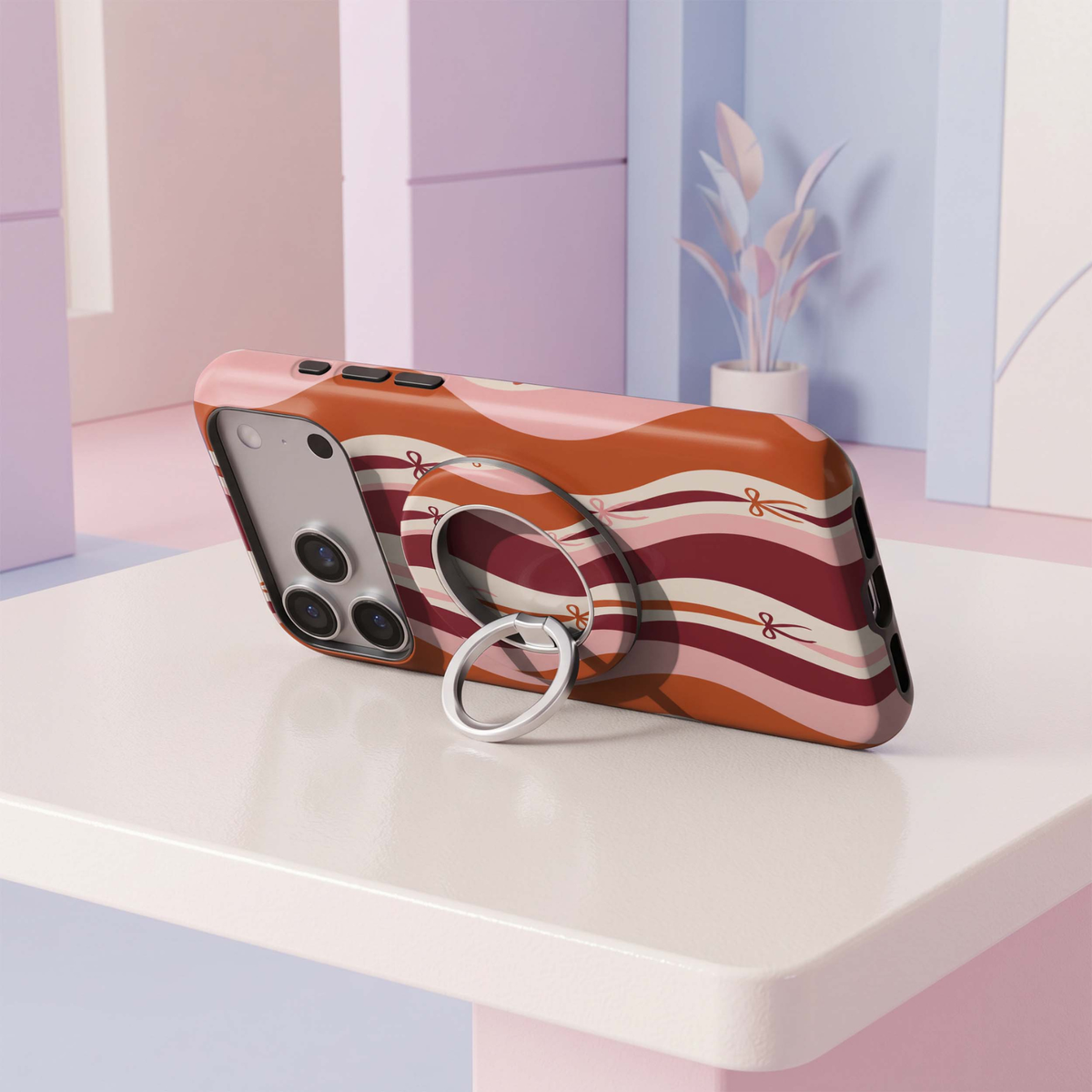 CASELIX Retro Ribbon MagSafe Ring Holder featuring wavy burgundy, burnt orange, cream and pink stripes with delicate bow accents and a silver metal ring.