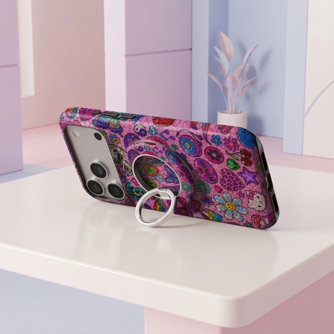 Colorful pink stained glass MagSafe ring holder featuring disco balls, hearts, rainbows, flowers, stars, and retro pop icons with a silver phone grip and stand.