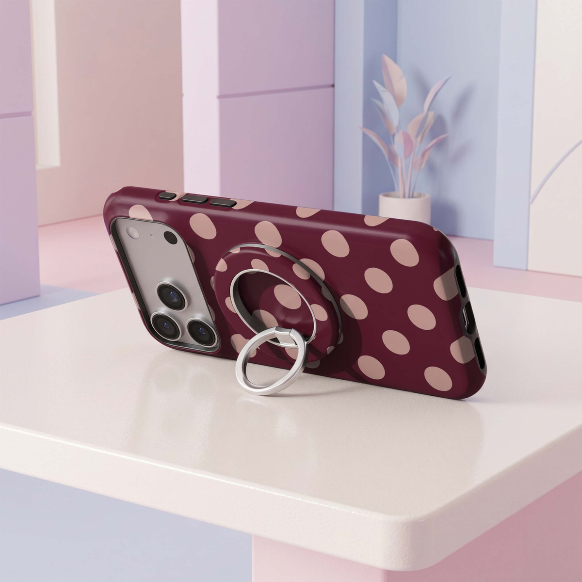 CASELIX Blush Dots MagSafe Ring Holder featuring soft blush pink polka dots on a deep burgundy background with a silver metal finger ring.