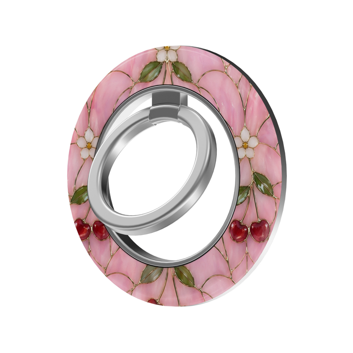 Cherry Blossom Glass MagSafe ring holder featuring red cherries, delicate white flowers and green leaves on a pink stained glass background with a silver magnetic phone grip.
