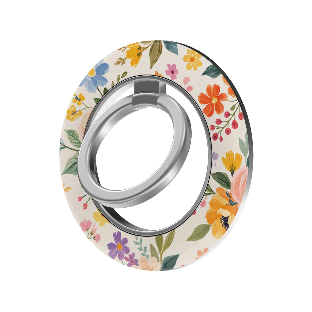 Meadow Bloom MagSafe ring holder featuring colorful wildflowers in orange, yellow, blue, pink and purple on a soft cream background with a silver magnetic phone grip.