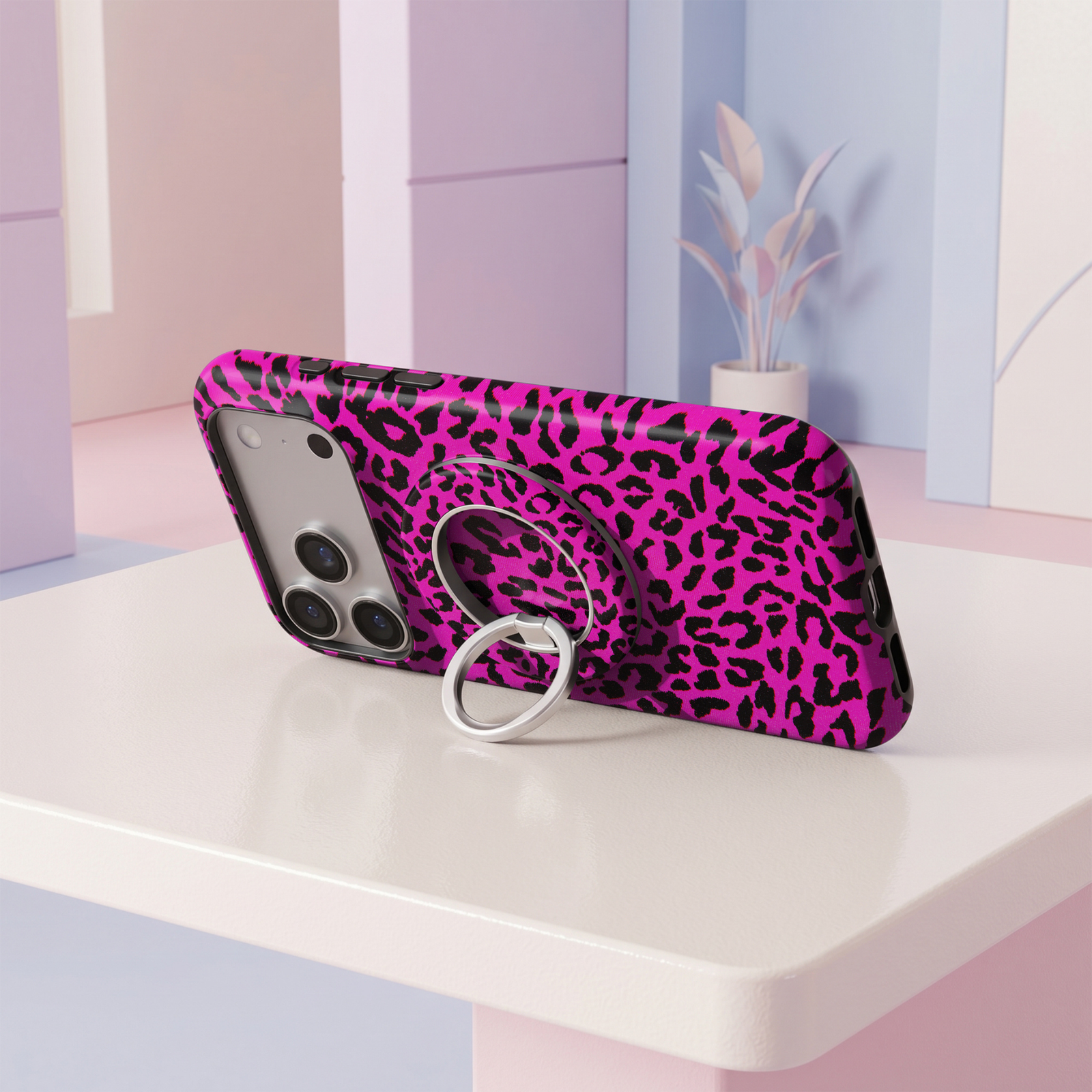 Vibrant hot pink and black leopard print MagSafe ring holder with a bold animal pattern and sleek silver magnetic phone grip and stand.