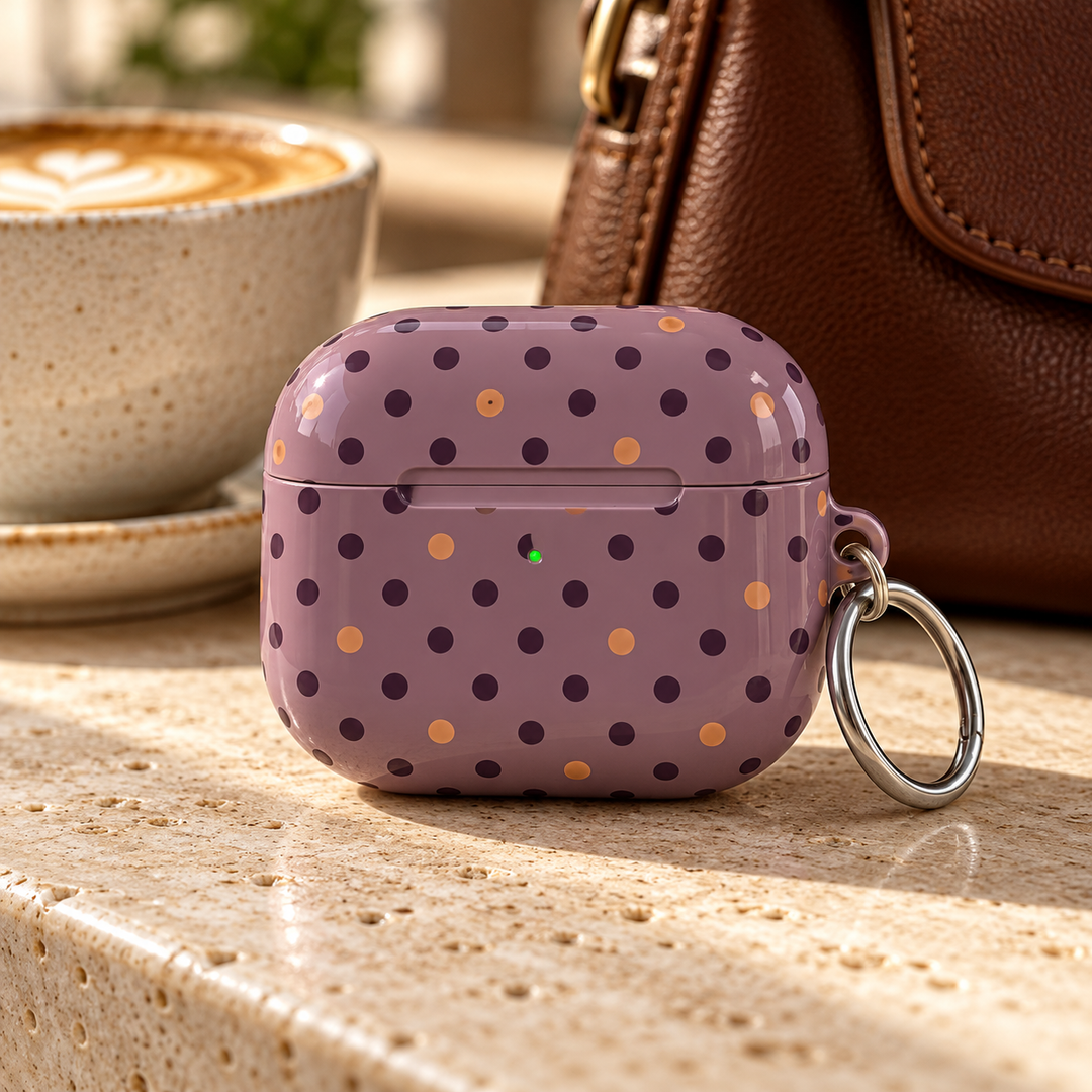 Autumn Confetti AirPods Case featuring a muted mauve background with deep burgundy and warm caramel polka dots and a silver carabiner.