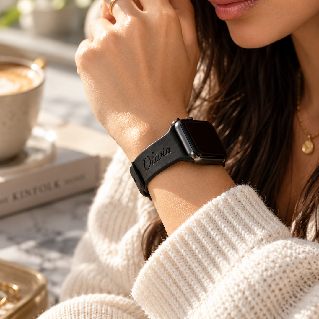 Personalized black Apple Watch band worn on the wrist with Olivia name engraving