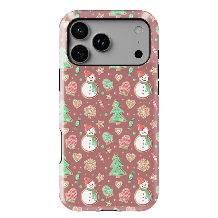 Cute Christmas iPhone case with gingerbread snowmen, holiday cookies, mittens, and festive icons on a warm pink background