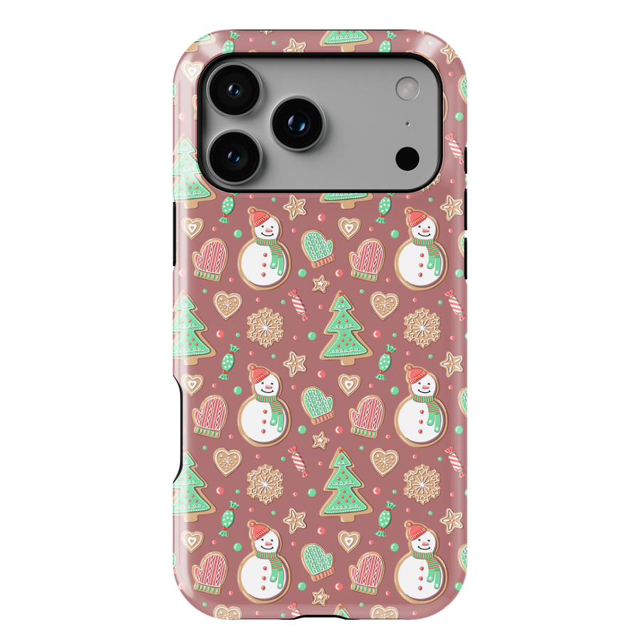 Cute Christmas iPhone case with gingerbread snowmen, holiday cookies, mittens, and festive icons on a warm pink background
