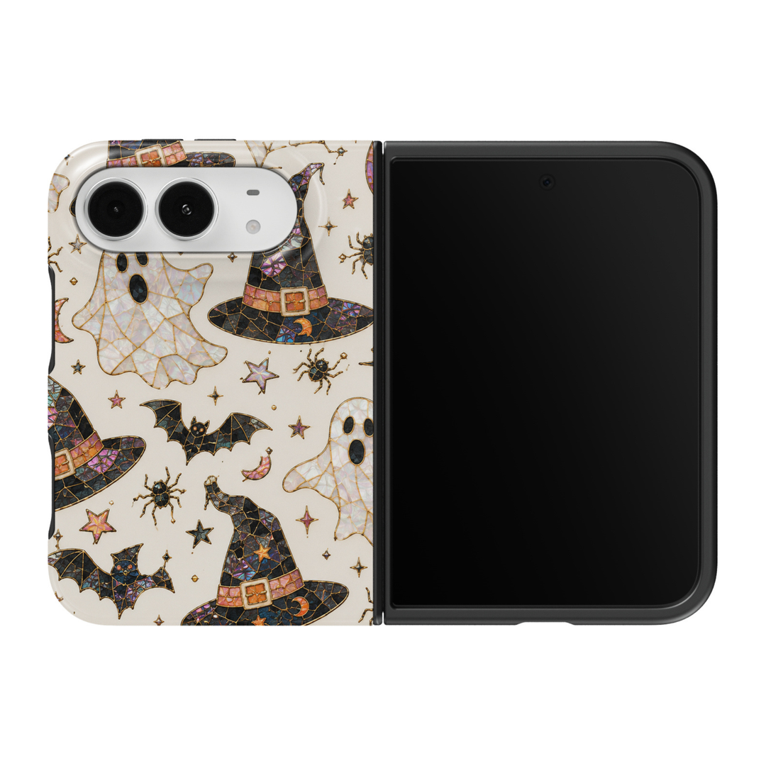 CASELIX Spooky Spell iPhone Duo Tough MagSafe folding phone case featuring a cream ivory background with iridescent stained-glass Halloween ghosts, black witch hats with gold buckles, flying bats, tiny spiders, crescent moons, and colorful celestial stars. Cute spooky Halloween phone case for women with pastel purple, pink, and gold mosaic accents, glossy printed finish, whimsical witchcore aesthetic, and protective two-piece foldable design.
