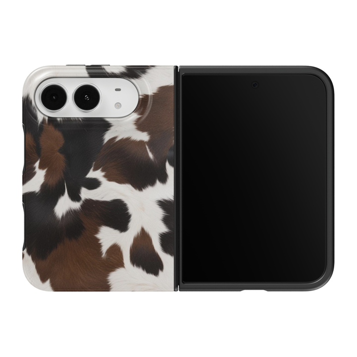 CASELIX Western Cowhide iPhone Duo Tough MagSafe folding phone case featuring a realistic brown, black, and white cow print pattern with irregular chocolate-brown patches, deep espresso markings, creamy ivory accents, and soft faux-fur-inspired detailing. Trendy Western cowgirl phone case for women with a glossy printed finish, rustic country-chic aesthetic, classic animal print design, and protective two-piece foldable construction.