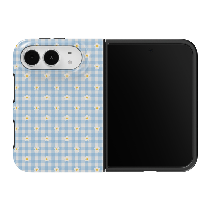 CASELIX Daisy Gingham iPhone Duo Tough MagSafe folding phone case featuring a pastel baby-blue and ivory-white gingham checkered background decorated with evenly spaced white daisy flowers and sunny yellow centers. Cute blue gingham floral phone case for women with a glossy printed finish, feminine cottagecore aesthetic, vintage picnic-inspired checkered pattern, preppy spring and summer fashion style, minimalist daisy artwork, and protective two-piece foldable construction.
