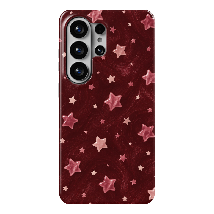 CASELIX Ruby Stardust Samsung Galaxy S26 Ultra Tough MagSafe protective phone case featuring a rich ruby-red and deep burgundy background adorned with glossy, three-dimensional-looking blush-pink stars, delicate rose-colored celestial accents, and scattered miniature pastel stars. The dreamy repeating pattern combines soft pink star illustrations, subtle shimmering textures, and elegant swirling marbled details for a romantic, whimsical night-sky aesthetic. Stylish burgundy Samsung Galaxy phone case for wom