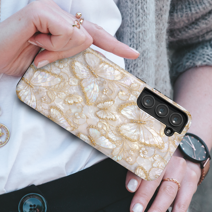 White pearl Samsung Galaxy case featuring elegant gold butterflies, opalescent floral artwork, and luxury feminine aesthetic design.