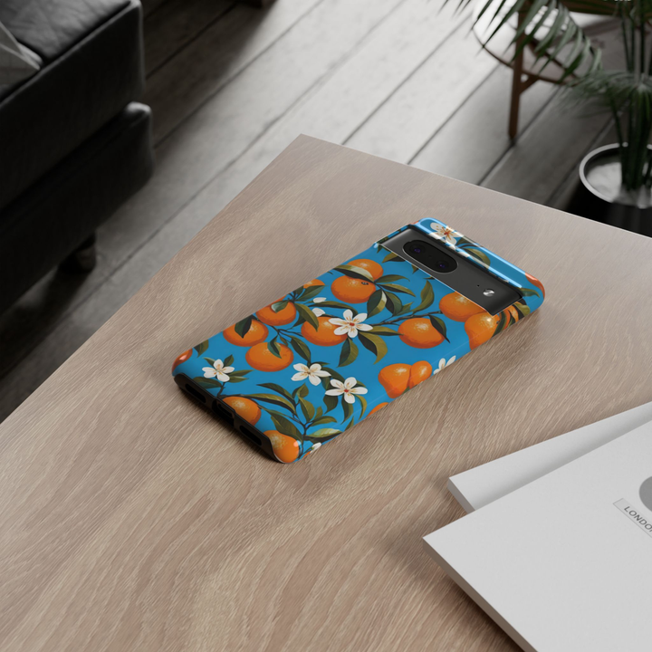 Google Pixel 10 protective phone case featuring vibrant oranges, white orange blossoms, and green leaves on a bright blue Mediterranean-inspired background.