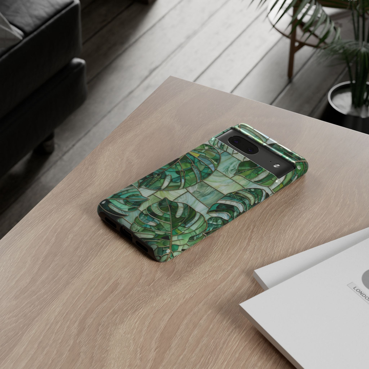 Google Pixel 10 protective phone case featuring a stained glass mosaic design with emerald green monstera leaves, tropical foliage, and elegant botanical artwork.
