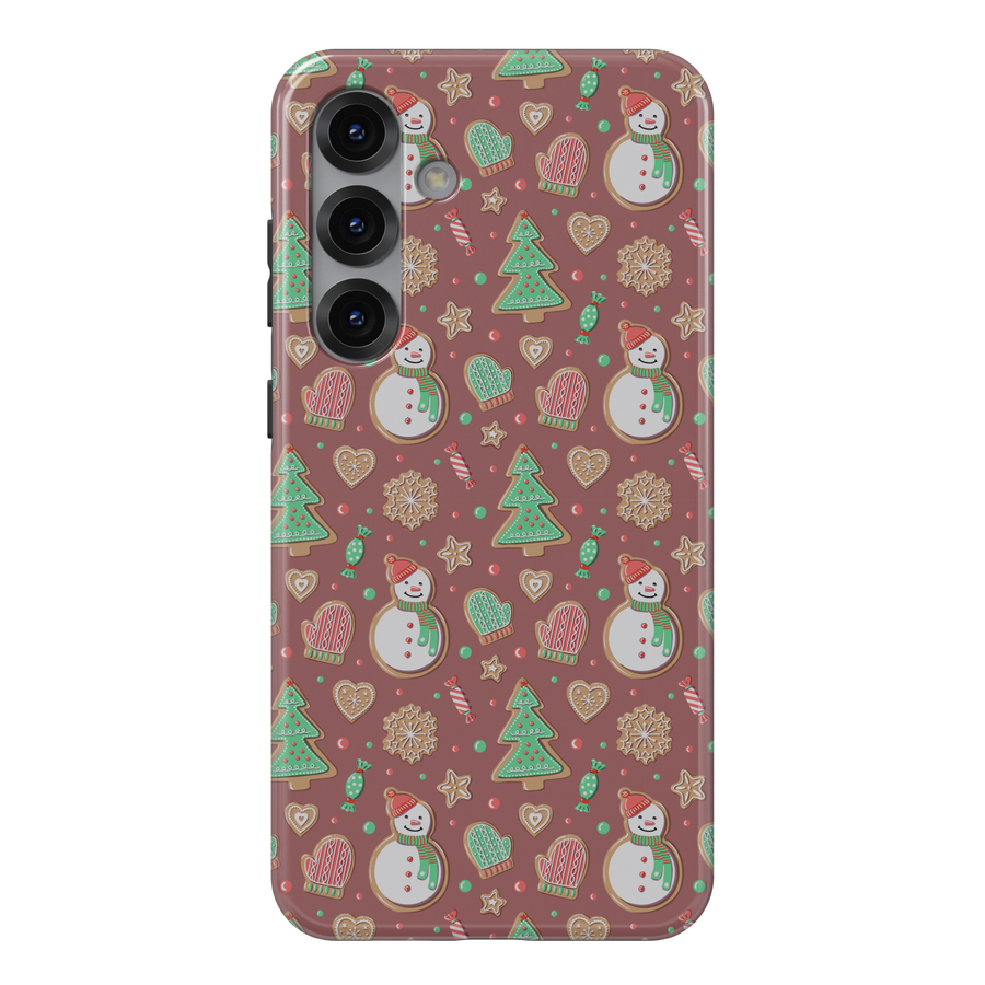 Cute Christmas iPhone case with gingerbread snowmen, holiday cookies, mittens, and festive icons on a warm pink background