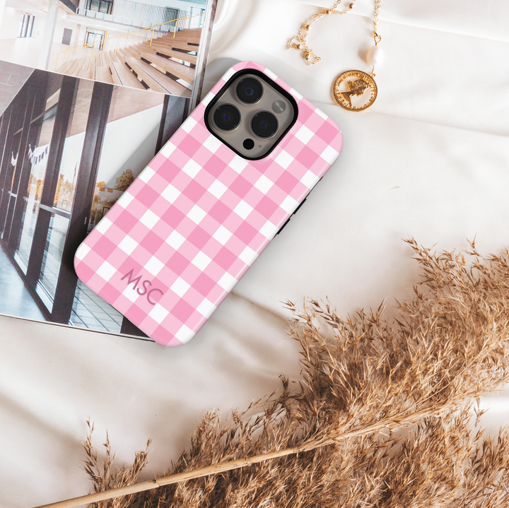 Personalized pink gingham iPhone case with custom initials. Cute checkered plaid phone cover in blush pink and white, designed for iPhone 15, iPhone 14, iPhone 13 Pro Max, and more. Aesthetic girly protective case with a trendy check pattern.