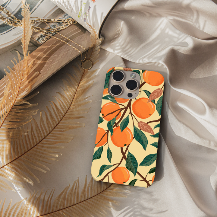 Orange fruit patterned iPhone case with leafy branch design on beige background. Summer aesthetic citrus phone cover for iPhone 15, iPhone 14, iPhone 13 Pro Max and more. Durable protective slim snap case.