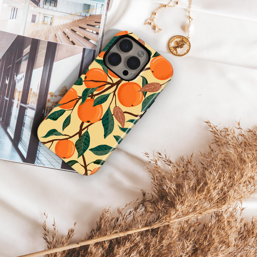 Orange fruit patterned iPhone case with leafy branch design on beige background. Summer aesthetic citrus phone cover for iPhone 15, iPhone 14, iPhone 13 Pro Max and more. Durable protective slim snap case.