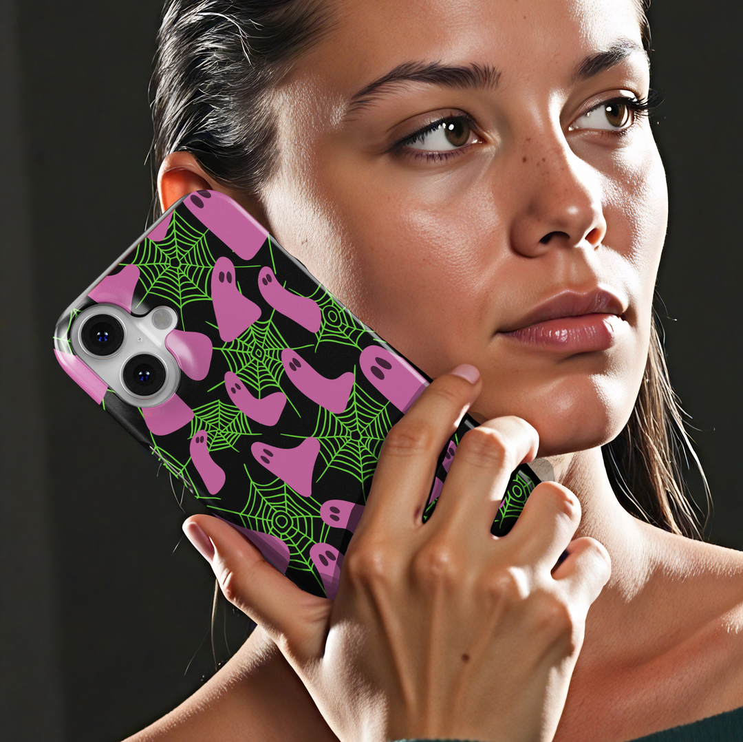 Neon Halloween iPhone case with pink ghosts and green spider webs on a black background. Cute spooky aesthetic protective phone cover for iPhone 15, iPhone 14, iPhone 13 Pro Max, and more. Fun girly ghost phone case perfect for Halloween season.