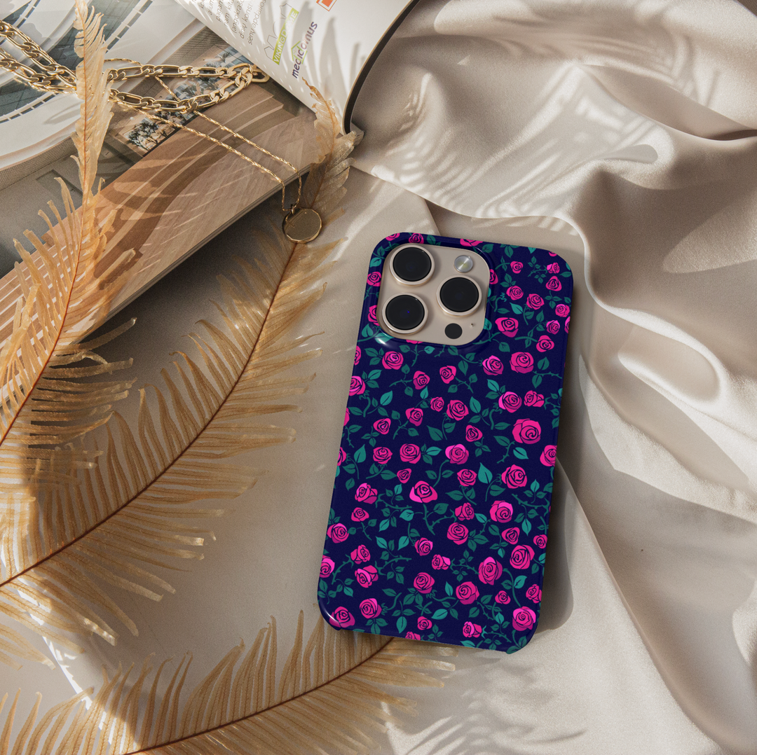 Pink rose floral iPhone case with navy blue background and green leaves. Romantic chic phone cover for iPhone 15, iPhone 14, iPhone 13 Pro Max and more. Protective slim snap case with elegant floral design.