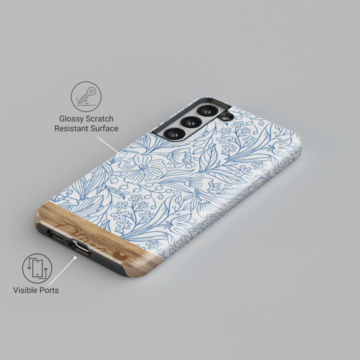 Elegant Samsung Galaxy phone case featuring a blue floral line art design with a woodgrain-textured bottom, personalized with a name engraving. Available for Samsung Galaxy S25 Ultra, S24 FE, S23, and more.