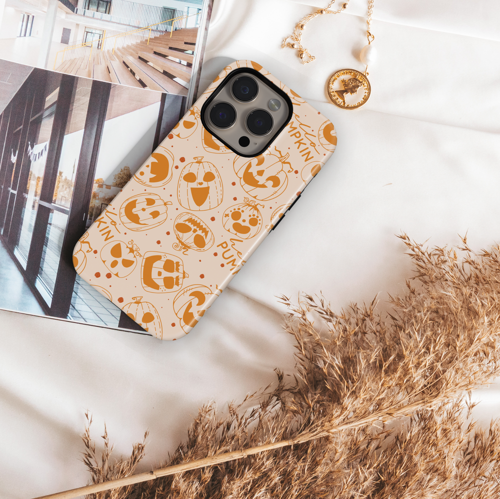 Pumpkin doodle Halloween phone case with orange jack-o’-lantern designs on a neutral background for iPhone and Samsung.