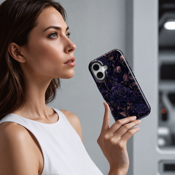 Gothic Halloween phone case with dark purple roses, vintage skull accents, moody floral pattern, spooky fall aesthetic cover for iPhone.